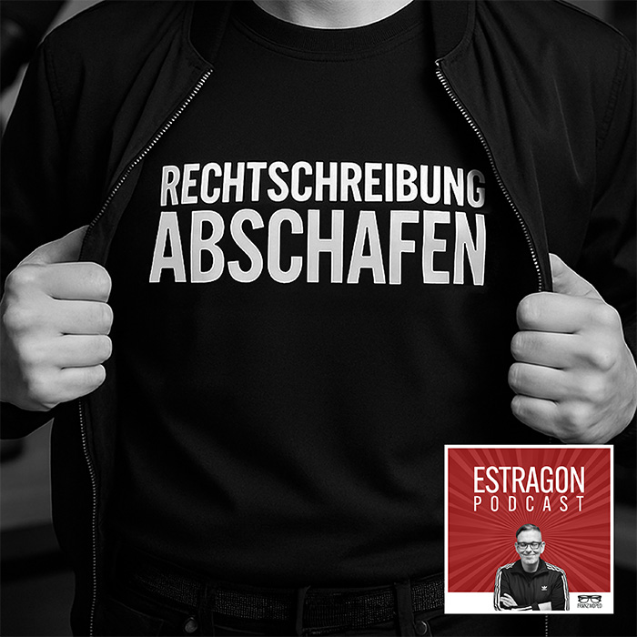 Person öffnet Jacke und zeigt ein schwarzes T-Shirt mit weißer Aufschrift „Rechtschreibung abschafen“, rechts unten das Logo des Estragon Podcast, verlinkt zur gleichnamigen Podcast-Folge