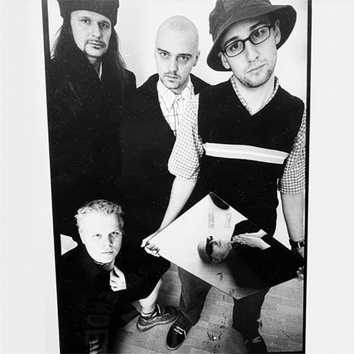 Bandfoto der Band Rank im Jahr 2000. Whoozn, Miguel, Martin Moped, Meister Paa. Letzterer hält einen Spiegel in der Hand, auf dem man Franz Moped am Boden liegend sieht. 