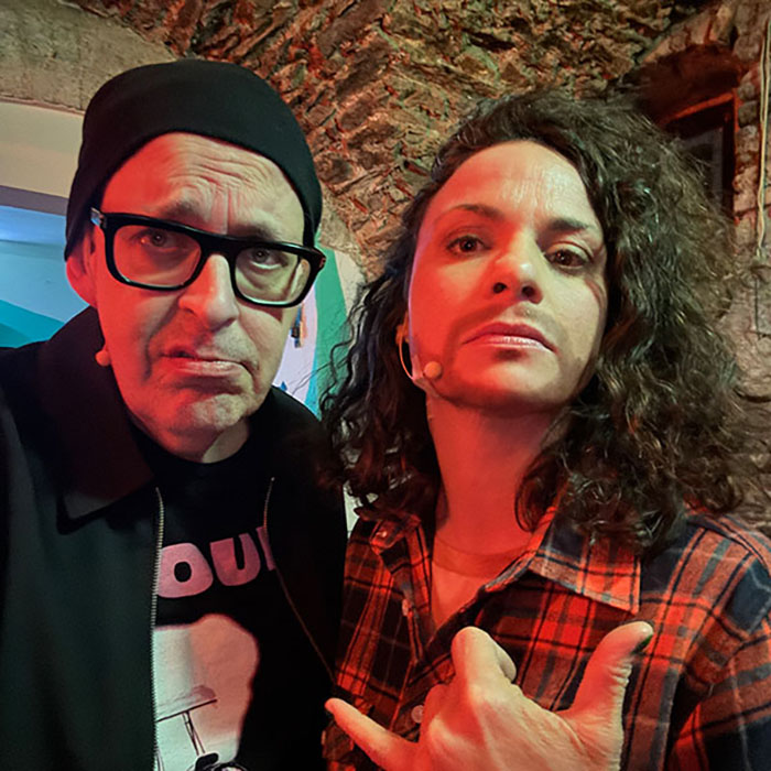 Antonia Stabinger und Franz Moped 2025 im Kulturhof Villach posen in die Kamera. Antonia Stabinger hat einen Bart aufgeschminkt. 